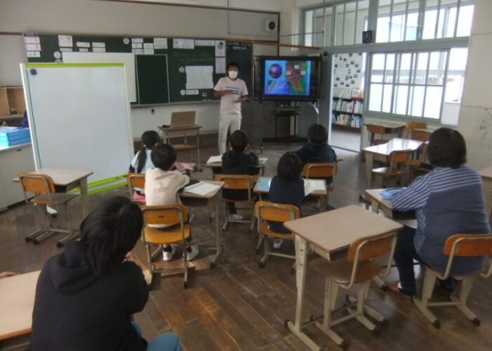 教室にて子供たちに深海についての授業を行う船長
