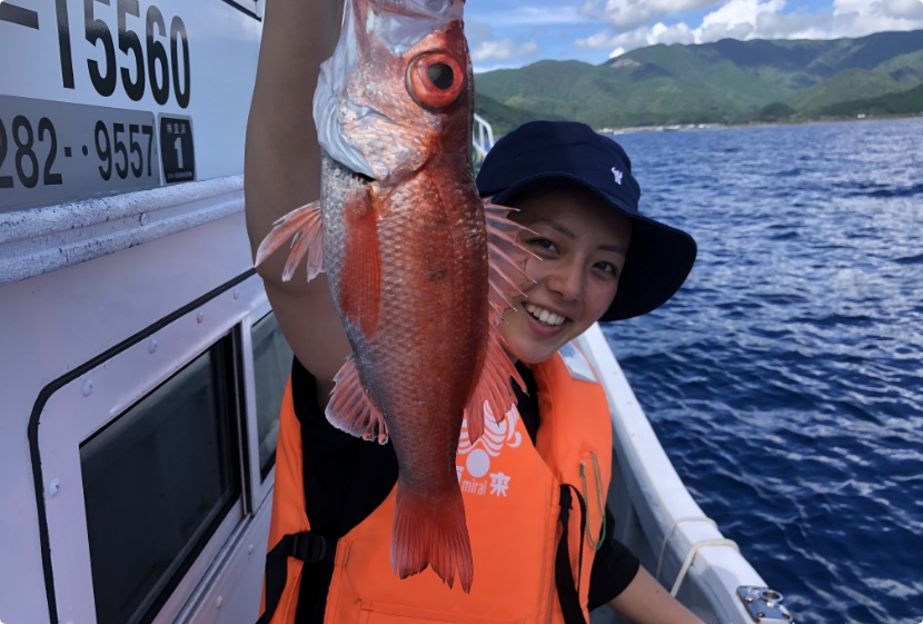 釣り上げた金目鯛を持つ女性