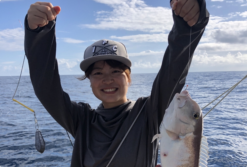 釣り上げた魚を持つ女性