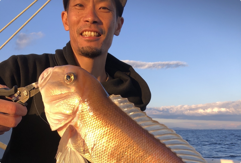 釣り上げた魚を持つ男性